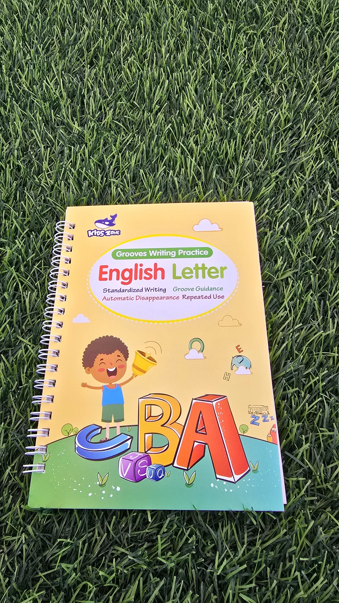 Adeo English Letter groove writing practice book photographed on grass